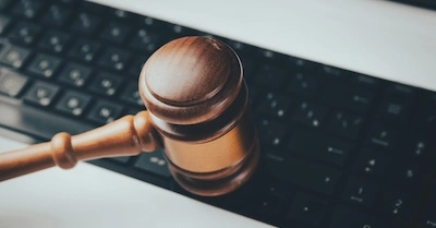 Wooden gavel sitting on computer keyboard